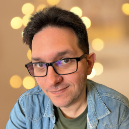 Black haired man with glasses with bokeh background